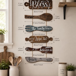 Peut inclure: Un ensemble de six d&eacute;corations murales de cuisine en bois en forme d'ustensiles et d'une planche &agrave; d&eacute;couper. Chaque pi&egrave;ce pr&eacute;sente du texte blanc incluant Bless, the FOOD BEFORE US, The Family BESIDE US, et the Love between us, avec des dimensions en cm.