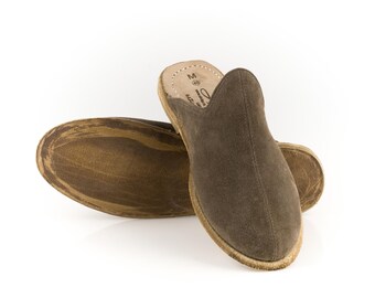 May include: A pair of brown suede slippers with a pointed toe and a closed back. The slippers have a leather sole and are made in Morocco.
