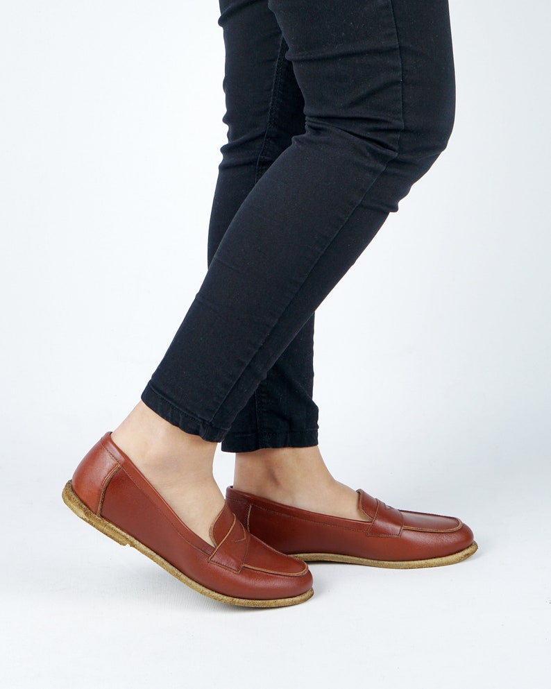 May include: A pair of brown leather loafers with a simple design. The loafers have a rounded toe and a low heel.