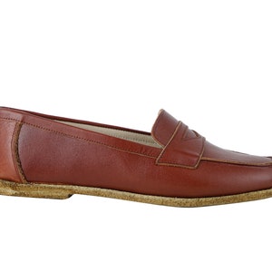 May include: A pair of brown leather loafers with a simple design. The loafers have a rounded toe and a low heel.