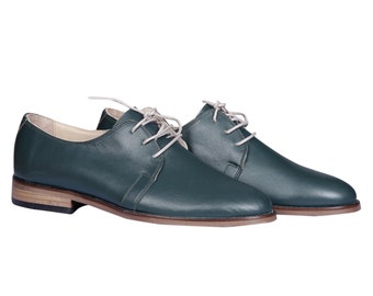 May include: A pair of dark green leather lace-up shoes with a low heel.