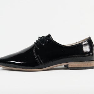 May include: Black leather lace-up shoes with a pointed toe and a low heel.