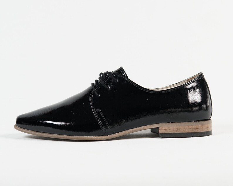 May include: Black leather lace-up shoes with a pointed toe and a low heel.