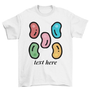May include: White t-shirt with a design of five colorful jelly beans and the text "text here" printed on the front.
