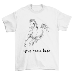 May include: White t-shirt with a black and white line drawing of a horse running. The text "your name here" is printed below the horse.