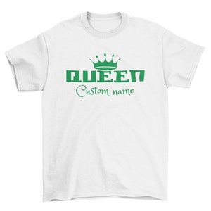 May include: White t-shirt with a green crown and the word "QUEEN" in green letters. The text "Custom name" is written in cursive below the word "QUEEN".