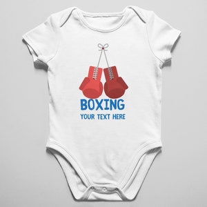 May include: White baby onesie with a red boxing glove graphic and the text "BOXING YOUR TEXT HERE" in blue.