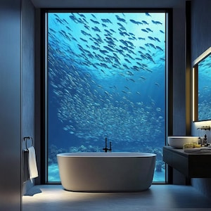 May include: A modern bathroom with a large window offering a view of a school of fish swimming in the ocean. The room features a white, oval-shaped bathtub, a dark vanity with a sink, and a towel rack.