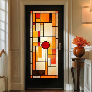 May include: A stained glass door with a geometric design in shades of orange, yellow, red, and black. The door is framed in black and set in a white doorway.