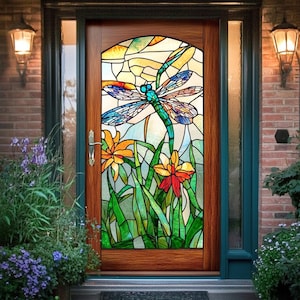 May include: A stained glass door featuring a dragonfly design. The dragonfly has blue, green, and orange wings and body. The door also features orange and red flowers and green grass. The door is framed in wood and set in a brick wall.