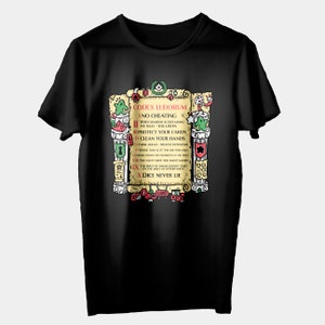Puede incluir: Camiseta negra con un gráfico de un rollo con el texto "CODEX LUDORUM" y una lista de reglas para jugar juegos. Las reglas incluyen "No hacer trampa", "Proteger tus cartas", "Limpiar tus manos" y "Los dados nunca mienten".