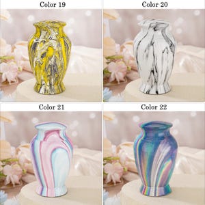 May include: Four small decorative urns with lids, each featuring a unique marbled finish. Color 19 is yellow and black, Color 20 is white and black, Color 21 is pastel pink and blue, and Color 22 displays a vibrant iridescent blue and purple swirl.