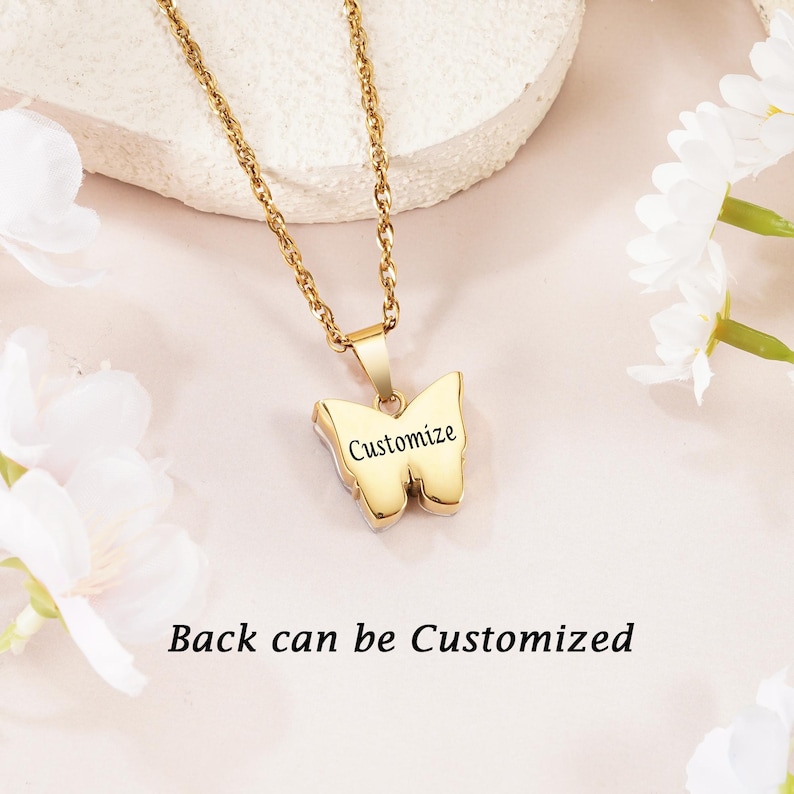 May include: A gold-toned metal necklace featuring a butterfly-shaped pendant. The front of the pendant is engraved with the word Customize. The text Back can be Customized is also visible in the image. The pendant hangs from a matching gold chain.