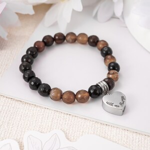 May include: Brown and black agate bead bracelet with a silver heart charm that reads "Always with me".