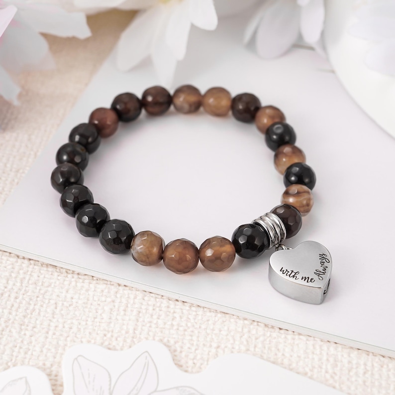 May include: Brown and black agate bead bracelet with a silver heart charm that reads "Always with me".