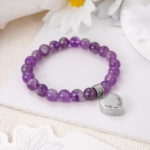 May include: Purple amethyst bead bracelet with a silver heart charm that reads "Always with me".