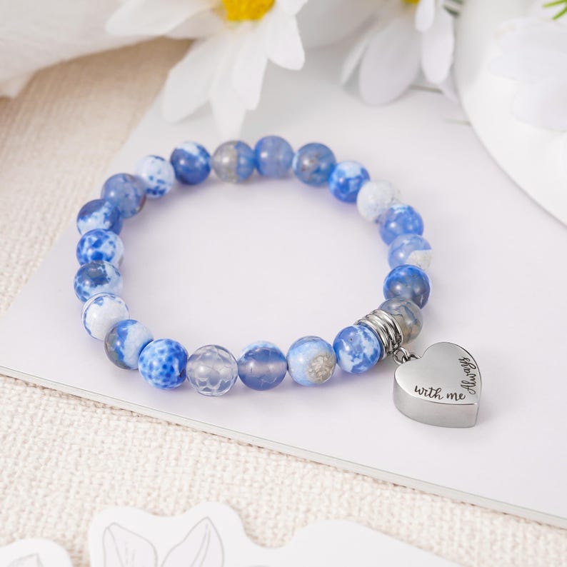 May include: Blue and white agate bead bracelet with a silver heart charm that reads "Always with me".