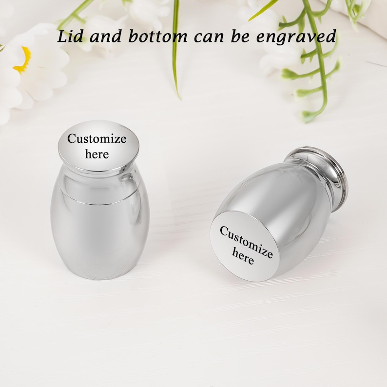 May include: Two silver-colored urns with rounded bodies and a lid. The text "Customize here" is printed on the lid and body of the urns. The text "Lid and bottom can be engraved" is above the urns.
