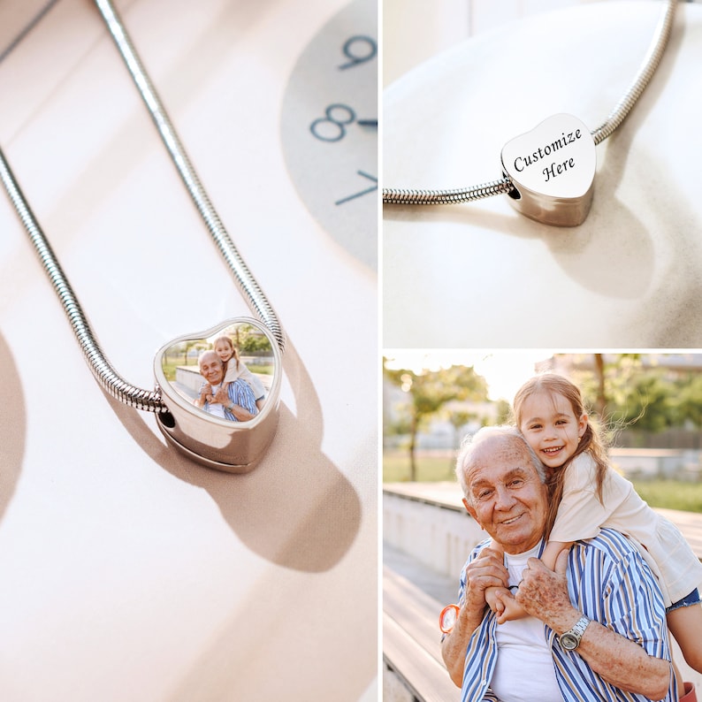 May include: A silver chain necklace with a heart-shaped charm. The charm has a photo of an older man and a young girl. The charm also has the text "Customize Here" engraved on it.