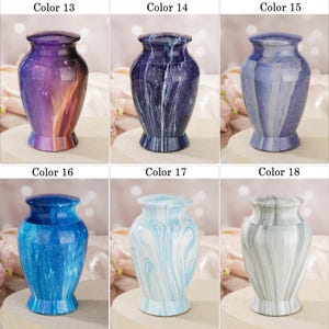 May include: A collection of six decorative urns labeled Color 13 through Color 18. Each urn features a distinct finish: purple and orange gradient, dark blue marble, light blue vertical stripes, bright blue speckled, light blue swirl, and grey swirl.