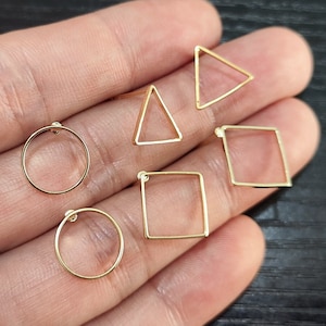 May include: A set of six gold-toned earring findings in different geometric shapes: two circles, two squares, and two triangles.