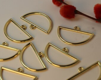 Peut inclure: Un ensemble de huit breloques pendantes en métal demi-cercle de couleur or avec une barre plate en haut. Chaque breloque a un petit anneau de saut attaché à la barre.