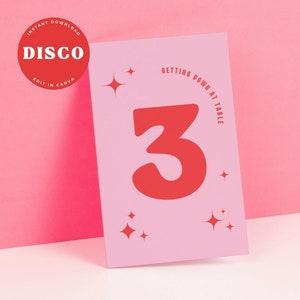 May include: Pink table number card with a large red number 3 and the text "Getting Down at Table". The card has a sparkly design.