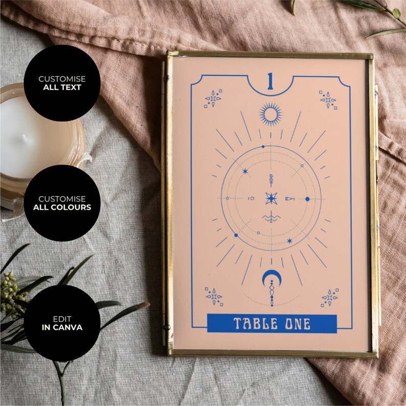 May include: A gold-framed table number card with a peach background and blue celestial design. The number "1" and the text "TABLE ONE" are in blue.