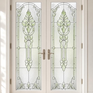 Può includere: Un set di porte doppie bianche con ampi pannelli in vetro decorati da piombatura e inserti in vetro colorato verde pallido. Il design include motivi floreali simmetrici, archi superiori e vetro testurizzato opaco.