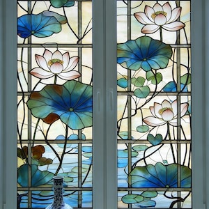 Könnte beinhalten: Buntglasfenster mit einem Lotusblumen-Design. Das Fenster ist in rechteckige Felder unterteilt. Die Lotusblumen sind rosa und weiß, mit großen blau-grünen Blättern. Vor dem Fenster steht eine dekorative Vase.