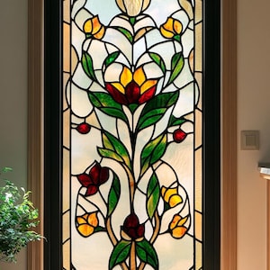 May include: A stained glass window featuring a floral design with yellow, red, and green flowers. The window is framed in black and set in a wooden door.