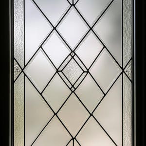 May include: A frosted glass window pane with a diamond pattern design. The window is framed in black.