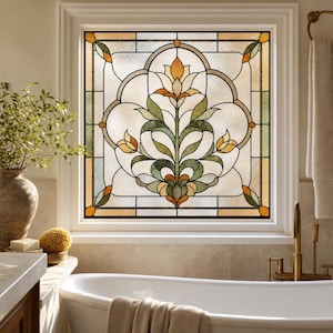 Puede incluir: Un panel de ventana cuadrado con un diseño de vidriera que presenta un motivo floral central en tonos ámbar, verde salvia y crema. El vidrio tiene un acabado texturizado y está enmarcado por líneas de plomo oscuras en un patrón simétrico.
