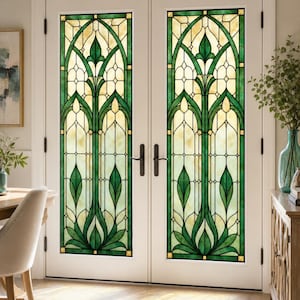 Può includere: Una coppia di porte doppie bianche con ampi pannelli in vetro colorato caratterizzati da un motivo botanico simmetrico nei toni del verde e del crema. Il design del vetro presenta linee arcuate e forme a foglia, con maniglie in metallo nero.