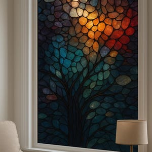 Puede incluir: Una vidriera con un diseño de árbol. La ventana presenta un mosaico de formas orgánicas coloridas en tonos azules, naranjas y amarillos. La ventana está enmarcada en blanco, con una lámpara y una silla en primer plano.
