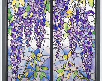 May include: Stained glass window panel with a wisteria design. The panel depicts hanging purple wisteria flowers with green and yellow leaves against a blue and white backdrop. The window is framed in black.