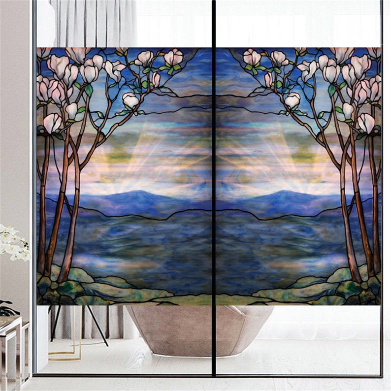 May include: A stained glass window film depicting a stylised landscape with a mountain range, a lake, and a tree with white flowers. The film features a blue, green, and purple colour scheme.