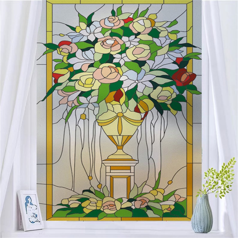 K&ouml;nnte beinhalten: Eine Buntglas-Fensterfolie mit einem Strau&szlig; bunter Blumen in einer gelben Vase auf einem Sockel. Die Blumen sind rosa, gelb, rot und wei&szlig;. Der Hintergrund ist hellgrau.