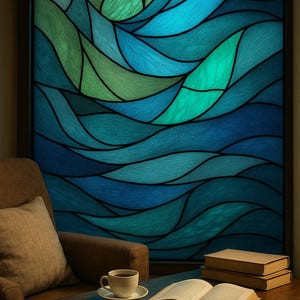 May include: A stained glass window with a flowing, abstract design in shades of blue and green. The window is set in a dark frame, with a brown armchair, a coffee cup, and books on a wooden table in front of it.