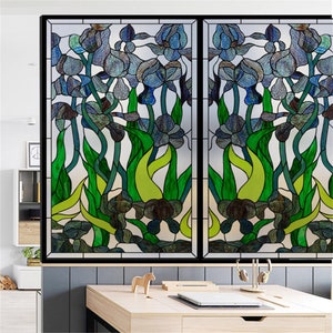 K&ouml;nnte beinhalten: Eine Fensterfolie im Stil eines Buntglasfensters mit einem floralen Design aus blauen Iris und gr&uuml;nen Bl&auml;ttern. Die Folie ist so konzipiert, dass sie wie ein traditionelles Buntglasfenster aussieht.