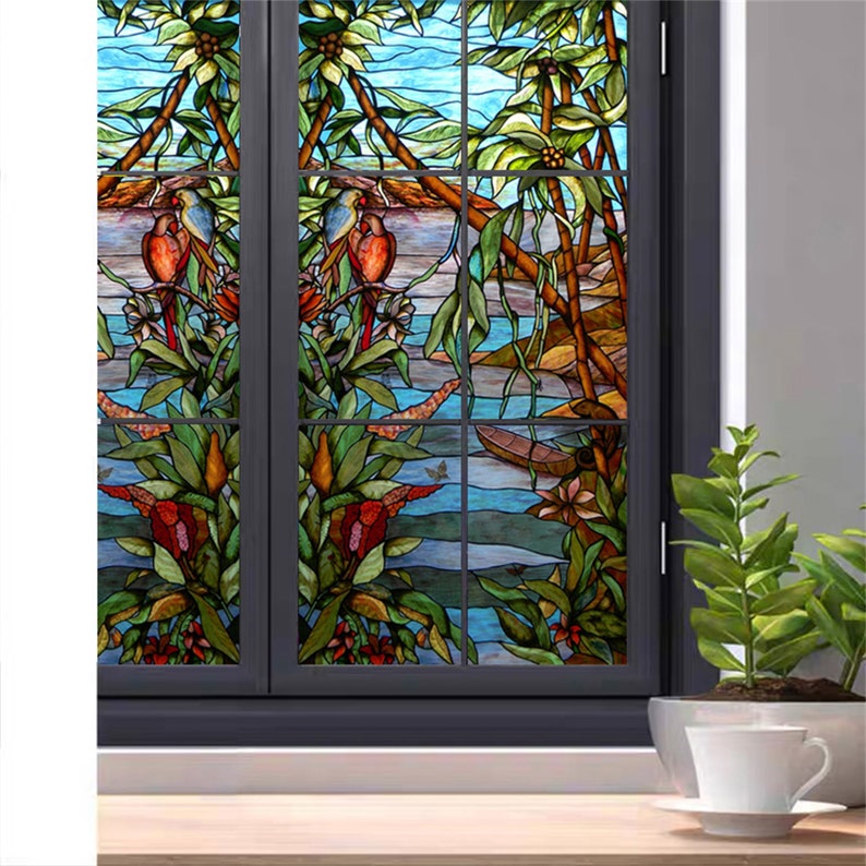 May include: A stained glass window film depicting a tropical scene with palm trees, birds, and a river. The film is designed to add privacy and style to any window.