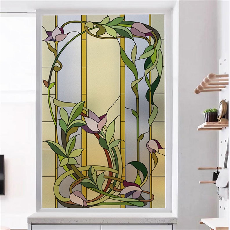 K&ouml;nnte beinhalten: Eine Buntglas-Fensterfolie mit einem floralen Design mit filigranen Details. Das Design umfasst stilisierte Blumen, Bl&auml;tter und Ranken in Gr&uuml;n-, Lila- und Gelbt&ouml;nen. Die Folie ist perfekt, um jedem Fenster einen Hauch von Eleganz und Privatsph&auml;re zu verleihen.