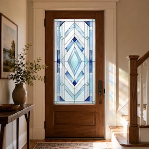 Può includere: Una porta in legno con una grande finestra rettangolare in vetro colorato dal motivo geometrico. Il vetro è composto da pannelli trasparenti, azzurri e blu scuro disposti in un disegno simmetrico a rombi e chevron con sottili profili metallici.