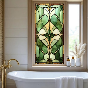 May include: A stained glass window featuring a floral pattern in green, yellow, and brown hues. The window is set in a wooden frame above a white bathtub with a gold tap. Decorative items, including bottles and a vase, are on the windowsill.