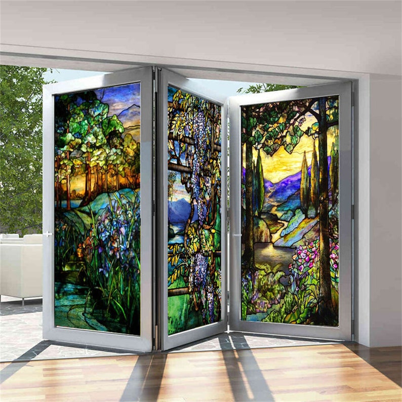 May include: A stained glass window film depicting a colourful landscape with trees, flowers, and a river. The film is divided into four panels, each with a different scene. The film is ideal for adding a touch of elegance and privacy to any room.