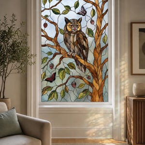 May include: A stained glass window film featuring a brown owl perched on a tree branch with green leaves, small purple butterflies, and reddish berries. The design uses a leaded glass pattern with textured, translucent panels in a rectangular frame.