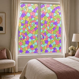 Op de afbeelding: Een raamfolie met een kleurrijk glas-in-loodpatroon met een herhalend spiraalontwerp. De folie bestaat uit onregelmatige geometrische vormen in tinten roze, paars, geel, groen en lichtblauw, wat een levendig mozaïekeffect creëert.