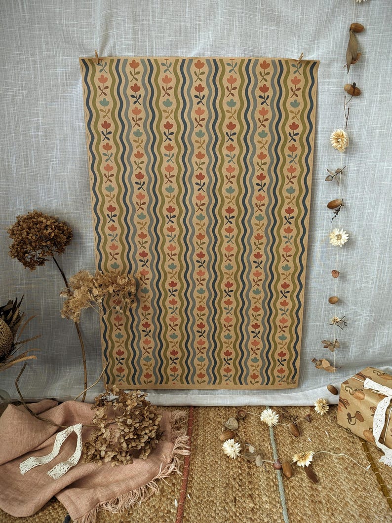 Puede incluir: Una l&aacute;mina de papel rectangular con un patr&oacute;n repetitivo de l&iacute;neas onduladas verticales en azul oscuro y verde oliva, intercaladas con peque&ntilde;os motivos florales estilizados en tonos coral, azul claro y rosa suave sobre fondo beige.