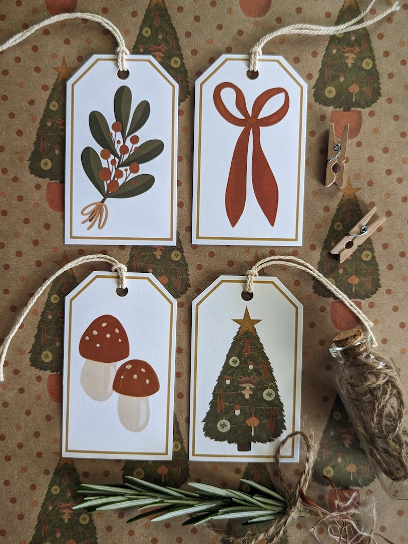 May include: Four illustrated gift tags with a gold border. The tags feature a sprig of holly, a red bow, a pair of mushrooms, and a decorated Christmas tree.