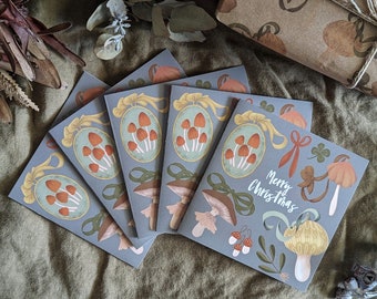 Puede incluir: Conjunto de seis tarjetas de Navidad ilustradas con setas y el texto "Merry Christmas". Las tarjetas están impresas sobre un fondo gris con una textura sutil.